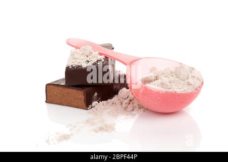 Whey Protein Pulver bei der Messung von Schaufel und Schokolade Protein Bar auf weißem Hintergrund. Gesunde Süßigkeiten. Stockfoto