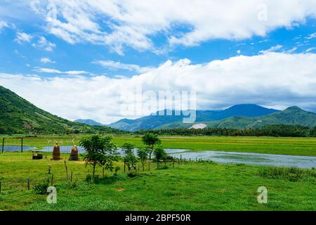 Ländliche Landschaft, Blick auf Reisfelder, schöne Aussicht auf Berge, Flüsse und einen Bauernhof Dorf. Blauer Himmel mit weißen Wolken. Wunderbare asiatische Landschaft Stockfoto