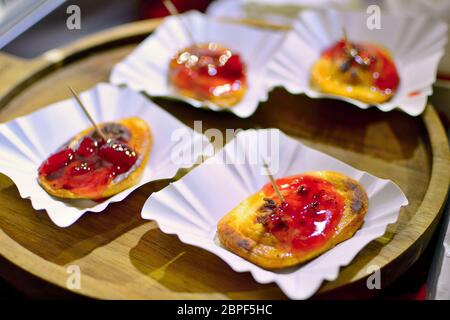 4 Portionen von gegrillten Oscypek (Traditionell geräucherter Käse aus Schafsmilch) mit Preiselbeeren auf hölzernen Platte serviert. Stockfoto