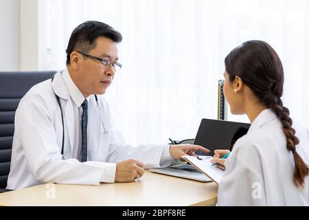 Zwei Ärzte im Krankenhaus die Diagnos des Patienten besprechen Stockfoto
