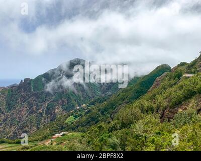 Panoramabild der Berge im Anaga Rural Park an einem sonnigen Tag mit weißen Wolken und dem Meer im Hintergrund, Teneriffa - Kanarische Inseln Stockfoto