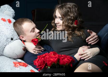 Liebhaber am Valentinstag. Junges Paar mit einem weichen Bären und einer roten Rose. Schönes Paar auf einem Date. Stockfoto