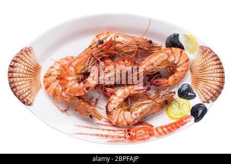 Meeresfrüchte Hintergrund. Nahaufnahme von frisch gegrillten Big Tiger Garnelen oder Shrimps auf einem bunten Seafood Platte auf einem weißen Hintergrund. Konzept gesunde fo Stockfoto