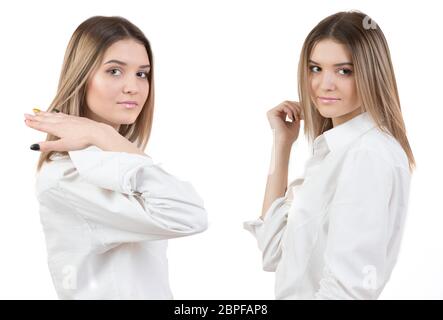 Zwei identische Mädchen in einer weißen Bluse. Zwillingsschwestern auf weißem Hintergrund. Stockfoto