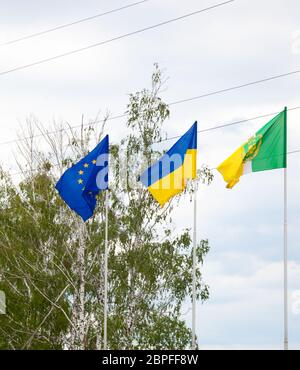 Die Flagge der Europäischen Union und der Ukraine flattert auf dem Fahnenmast. Flaggen Europas. Stockfoto