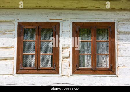 Altes traditionelles polnisches Holzhaus im Freilichtmuseum, Museum des Dorfes Kielce (Muzeum WSI Kieleckiej), Fenster mit handgefertigtem Spitzenvorhang, Toka Stockfoto