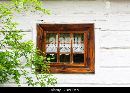 Altes traditionelles polnisches Holzhaus im Freilichtmuseum, Museum des Dorfes Kielce (Muzeum WSI Kieleckiej), Fenster mit handgefertigtem Spitzenvorhang, Toka Stockfoto