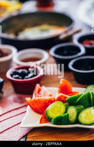 Das traditionelle Frühstück Gerichte mit Tomaten Gurken und schwarzen Oliven auf Tisch Stockfoto