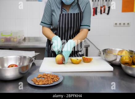 Frau in Schürze schneiden Äpfel zum Backen Kuchen Stockfoto