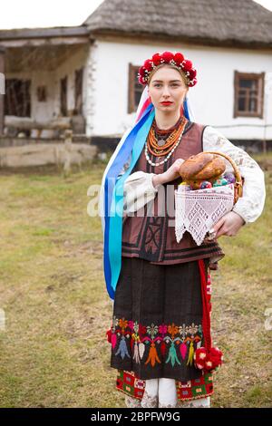 Schönes Mädchen in Nationalkleid mit Ostern und Eiern in einem Korb. Osterferien. In alten Kleidern des 19. Jahrhunderts. Mit Kranz und Bändern. Agai Stockfoto