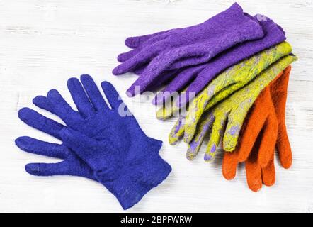 Werkstatt von Hand eine Fleece Handschuhe aus Schafwolle nass Filzen Prozess - Diverse woolen handgefertigte gefilzte Handschuhe auf hölzernen Tisch Stockfoto