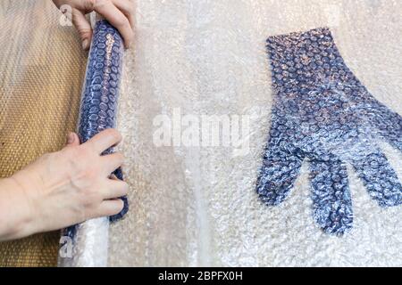 Werkstatt von Hand eine Fleece Handschuhe von blau Merino Schafschurwolle nass Filzen Prozess - Handwerker Brötchen gefilzte Handschuhe in Matte für Walken Stockfoto