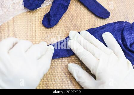 Werkstatt von Hand eine Fleece Handschuhe von blau Merino Schafschurwolle nass Filzen Prozess - Handwerker kondensierend Finger der gefilzten Handschuh Stockfoto