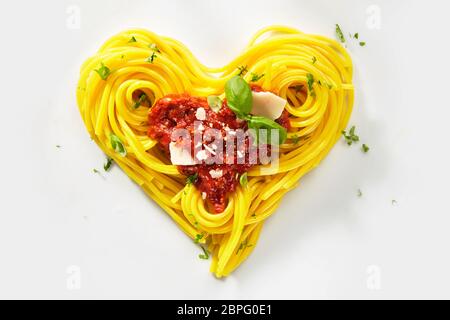 Dekorative Herzform Nudeln noch Leben geformt von gekochten Spaghetti mit Tomaten, Basilikum und Parmesan Stockfoto