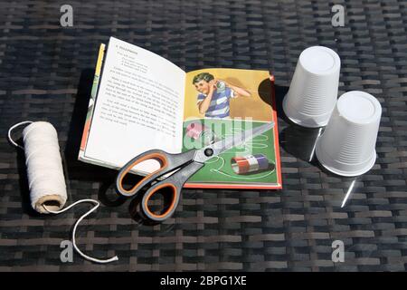 Marienkäfer Buch von Spielzeug und Spielen - ein Telefon aus Plastikbechern und String, Wissenschaft Experiment zu Hause mit Schallwellen und Vibrationen Stockfoto