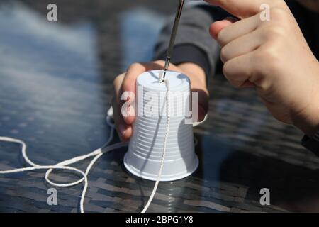 Aus Plastikbechern und Schnur ein Telefon zu machen, experimentiert die Wissenschaft mit Schallwellen und Vibrationen Stockfoto