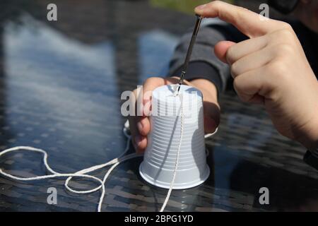 Ein Telefon aus einem Papier / Kunststoff Tasse und String, Home School Wissenschaft Experiment mit Schallwellen und Vibrationen, Großbritannien Stockfoto