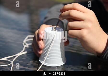 Aus Plastikbechern und Schnur ein Telefon zu machen, experimentiert die Wissenschaft mit Schallwellen und Vibrationen Stockfoto