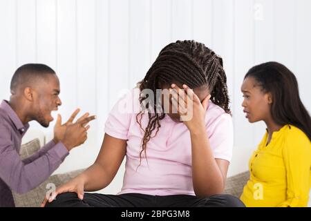 In der Nähe des Umgekippten afrikanisches Mädchen sitzt Vor Eltern in Argument Stockfoto