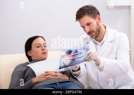 Nahaufnahme von einem männlichen Arzt erklären, X-ray zu weiblichen Patienten in der Klinik Stockfoto