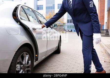 Der Parkservice Hand öffnen Grau Autotür auf der Straße Stockfoto