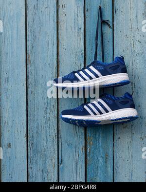Paar männlich blau Textil Sneakers auf einem blauen Holzwand Stockfoto