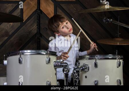 Der Junge lernt, Schlagzeug zu spielen. Das Kind hinter dem Schlagzeug. Stockfoto