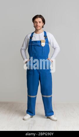 Professioneller Maler in Arbeitskleidung mit Pinsel in der Tasche gekleidet Stockfoto