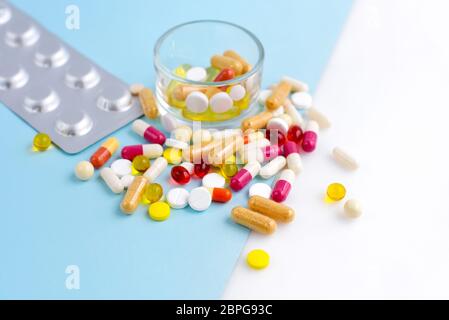 Verschiedene pharmazeutische Medizin Pillen, Tabletten und Kapseln auf blauem und weißem Hintergrund. Stockfoto