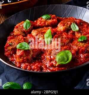 Gebackene mini Hackbällchen in Tomatensauce mit Basilikum Stockfoto