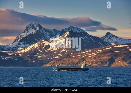 Berge vom Meer bei Tromso an der Westküste Norwegens, Skandinavien. Kleines Schiff segelt im Vordergrund Stockfoto