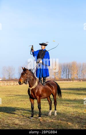 HORTOBAGY, UNGARN, NOVEMBER 04. 2018: Ungarische Csikos in traditioneller Tracht zeigen sein ausgebildetes Pferd. Traditioneller Pferdeherber von Hung Stockfoto