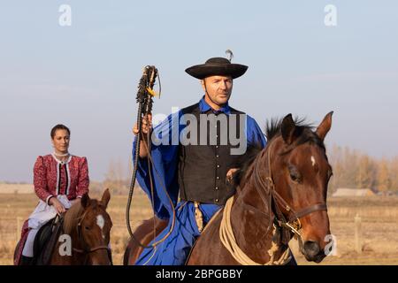 HORTOBAGY, UNGARN, NOVEMBER 04. 2018: Ungarische Csikos in traditioneller Tracht zeigen sein ausgebildetes Pferd. Traditioneller Pferdeherber von Hung Stockfoto