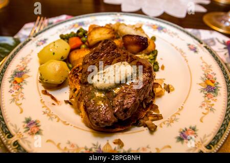 Gegrilltes Filetsteak mit geschmolzener Knoblauchbutter mit Gemüse auf dem Bett von Toast und Zwiebeln auf china-Teller Stockfoto