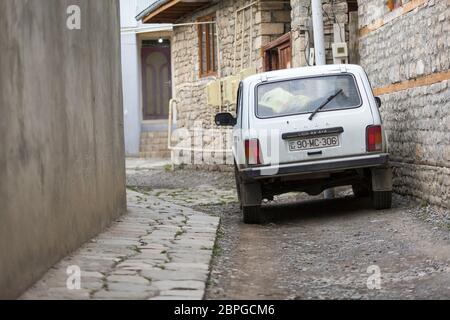 Ein russischer Lada Niva 4x4 parkte in den engen gepflasterten Gassen von Lahic in Aserbaidschan Stockfoto