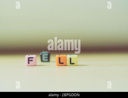 FELL Wort geschrieben in Würfel auf Holzboden auf weißem Hintergrund, Buchstaben Blöcke angeordnet in FELL Worte, für das Hinzufügen von Text oder andere Bilder oder Design Stockfoto