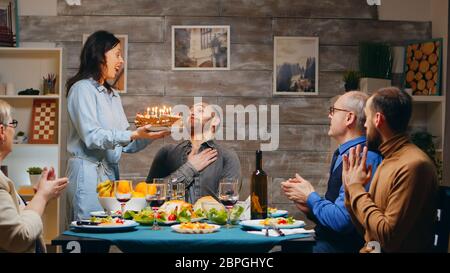 Junger Mann feiert seinen Geburtstag mit der Familie. Abendessen. Leckerer Kuchen. Zeitlupe aufgenommen Stockfoto