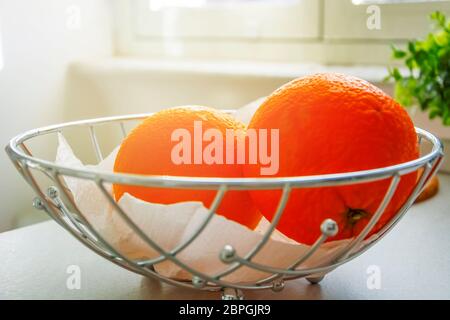 Ein paar Orangen in einem Metallkorb. Gesundes Essen. Zitrusfrüchte Stockfoto