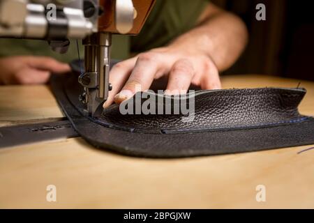 Hinzufügen von schwarzen Ledertasche auf einer Industrienähmaschine Stockfoto