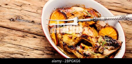 Gebackene Chicken Drumsticks mit Orangensauce in Auflaufform Stockfoto