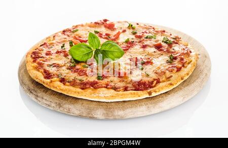 Seitenansicht des frisch gebackenen Margherita Pizza serviert auf runden hölzernen Schneidebrett auf weißem Hintergrund Stockfoto