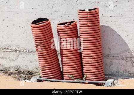 Rot Orange Wellpappe Ummantelung für elektrische Leitungen, auf ein Gebäude, Baustelle. Stockfoto