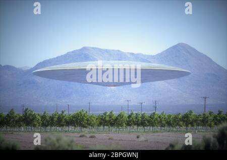 Unbekanntes Flugobjekt - UFO, fliegen über Plantagen in Wüste, mit Bergen im Hintergrund. Stockfoto