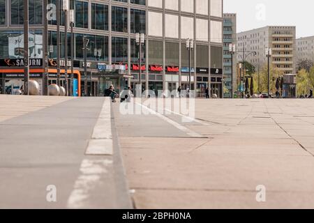 Leerer Alexanderplatz während der Koronakrise. Nur wenige Menschen gehen durch die Pandemie mit Covid-19 über den Alexanderplatz Stockfoto