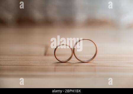 Ein Paar goldene Eheringe auf dem gelben Holzboden Stockfoto