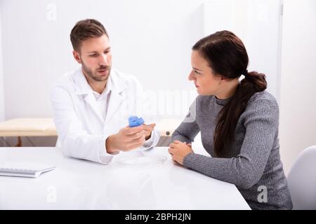 Junge männliche Arzt, Informationen über die Verwendung von Sauerstoff Maske zu Frau in Klinik Stockfoto