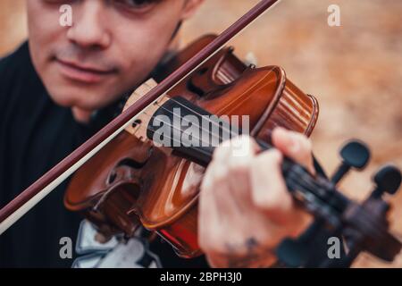 Junge Mann spielt Geige in den Wald. Stockfoto