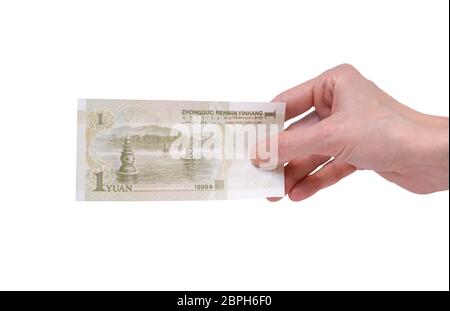 Weibliche Hand mit einer chinesischen Yuan-Banknote auf weißem Hintergrund isoliert. Stückelung von 1 Yuan. Stockfoto