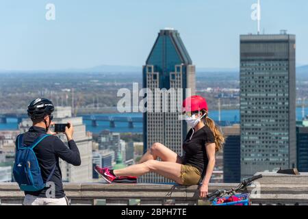 Montreal, CA - 18 May 2020 : Junge Frau mit Gesichtsmaske inmitten des Coronavirus Ausbruch posiert für Fotografie vor der Skyline von Montreal. Stockfoto