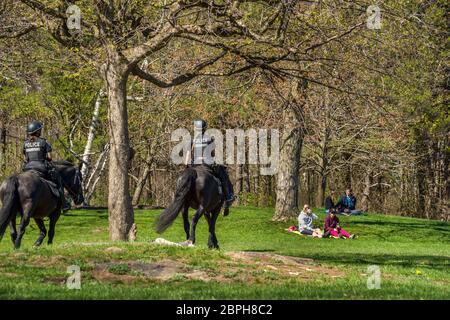 Montreal, Kanada - 16. Mai 2020: Berittene Polizei patrouilliert durch öffentliche Parks, um die Gesetze zur physischen Entfernung des Coronavirus im Mount Royal Park durchzusetzen Stockfoto